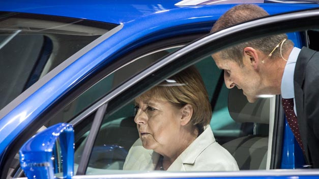 Bundeskanzlerin Angela Merkel saß am 17.09.2015 in Frankfurt/M. (Hessen) nach der offiziellen Eröffnung der 66. IAA am Stand von Volkswagen am Steuer eines Hybridfahrzeug vom Typ Tiguan GTE, den sie von VW-Markenvorstand Herbert Diess (r) erklärt bekam.